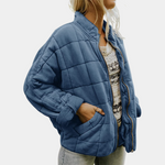 Blue quilted puffer jacket with zip front, stand collar, and side pockets