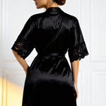 Black satin nightshirt robe from back view with lace-trim sleeves and waist tie