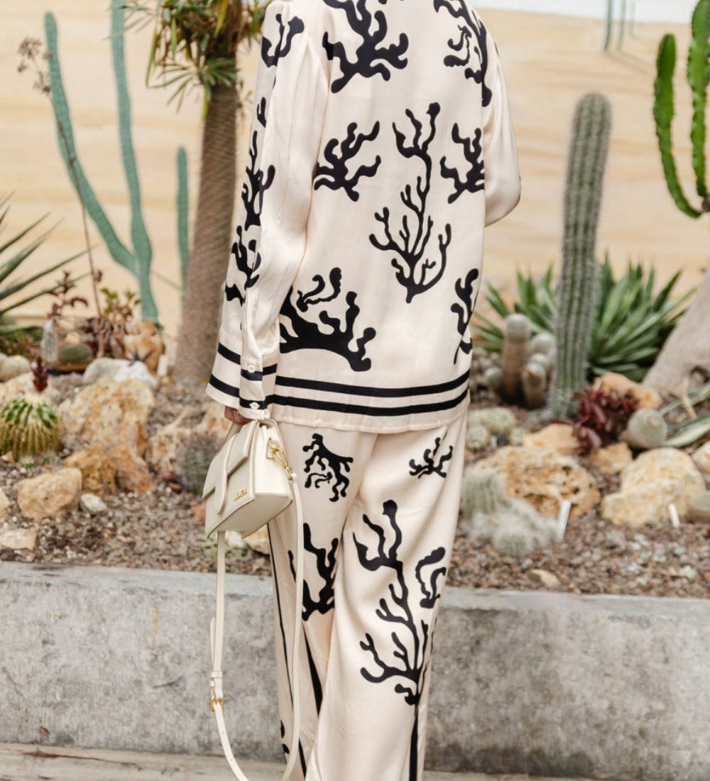 Silk pajama set in cream with black coral print, collared button shirt and wide-leg trousers