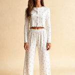 White capri pajama set with long sleeves, pink floral dots, elastic waist and wide legs.