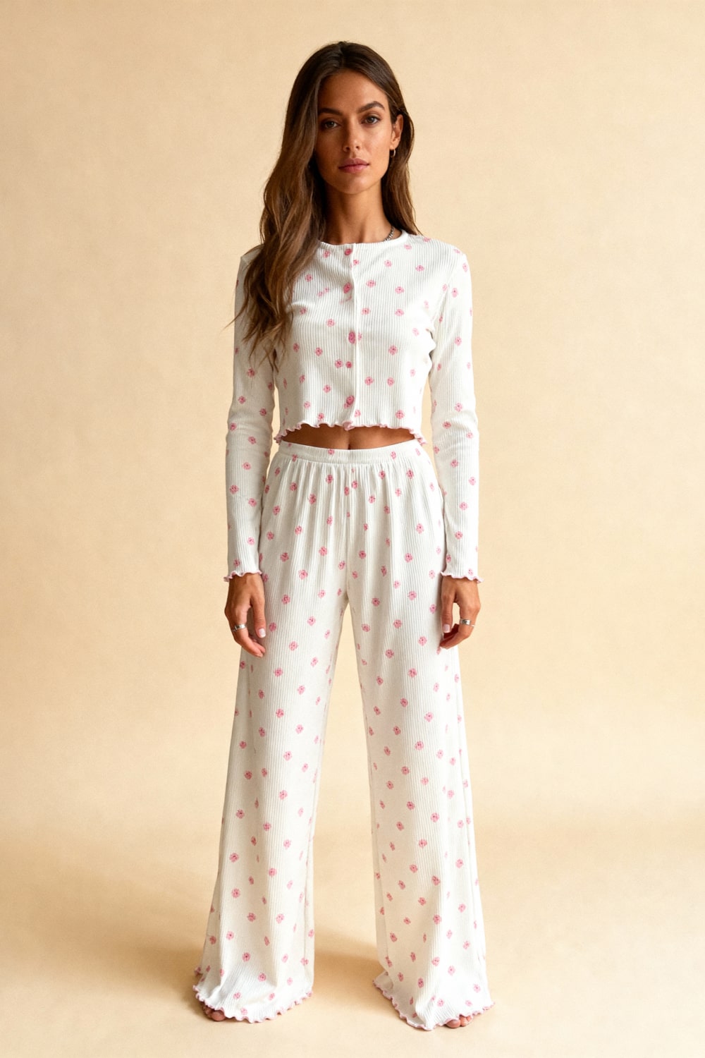 White capri pajama set with long sleeves, pink floral dots, elastic waist and wide legs.