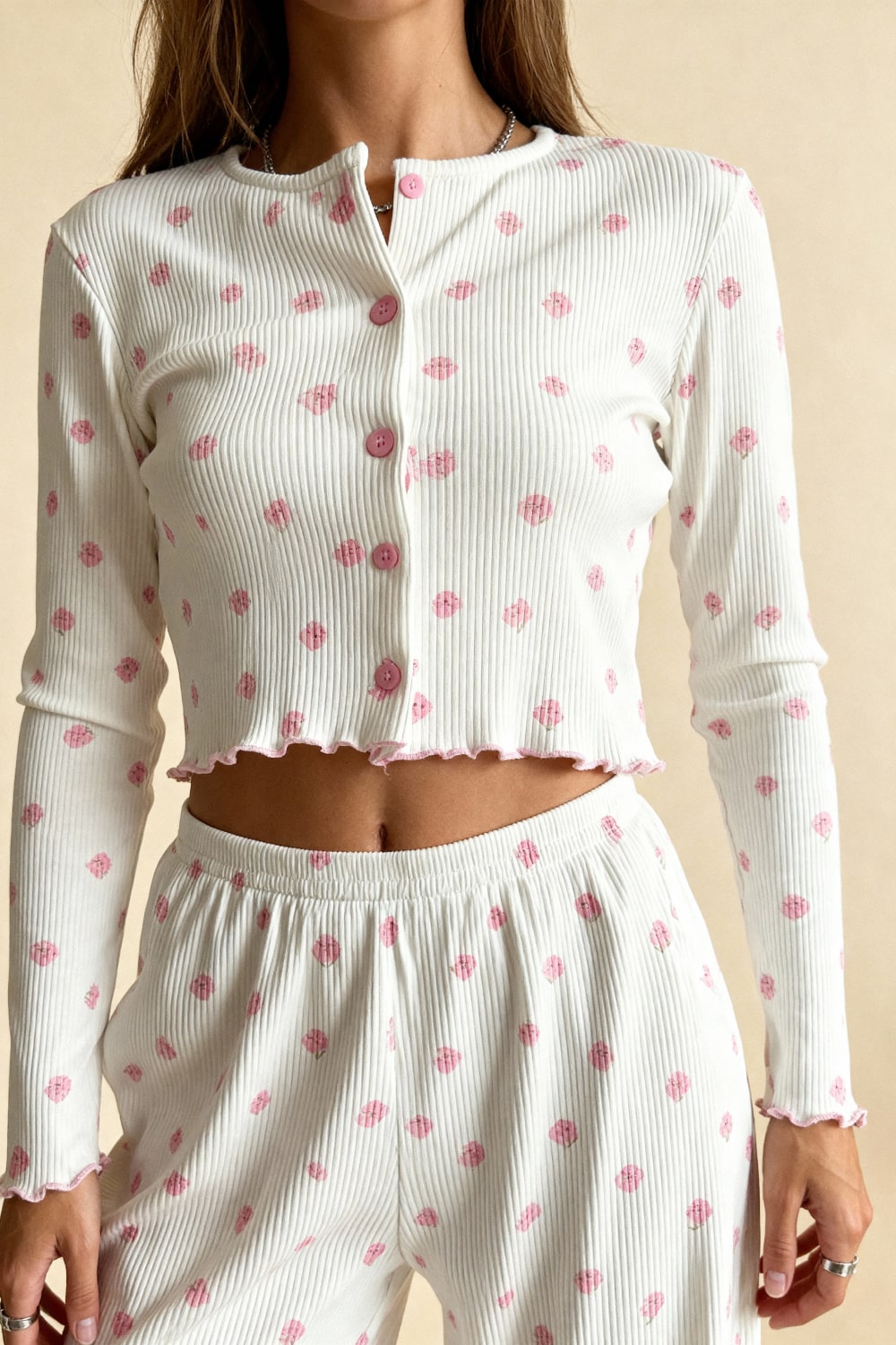 White long-sleeve pajama crop top with pink button placket and scattered pink flower print.