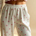 White capri pajama pants with pink flower print, elastic drawstring waist and gathered cuffs.