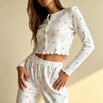 White long-sleeve capri pajama set with pink flower print, cropped top and elastic waist pants.