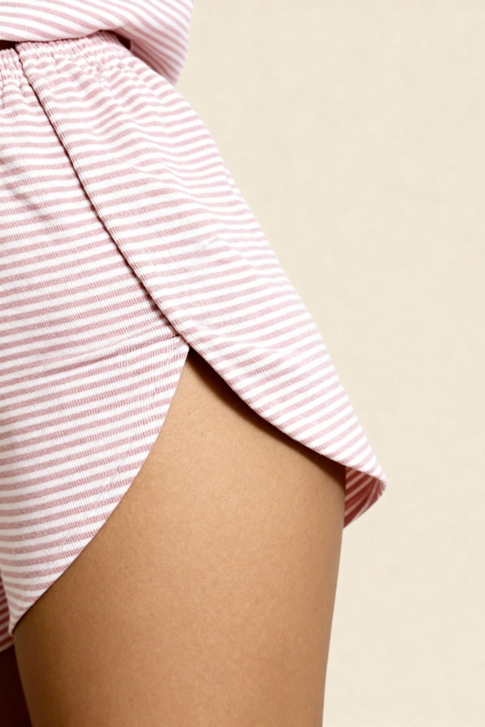 Pink striped shorts with elastic waistband and gathered hem, close-up