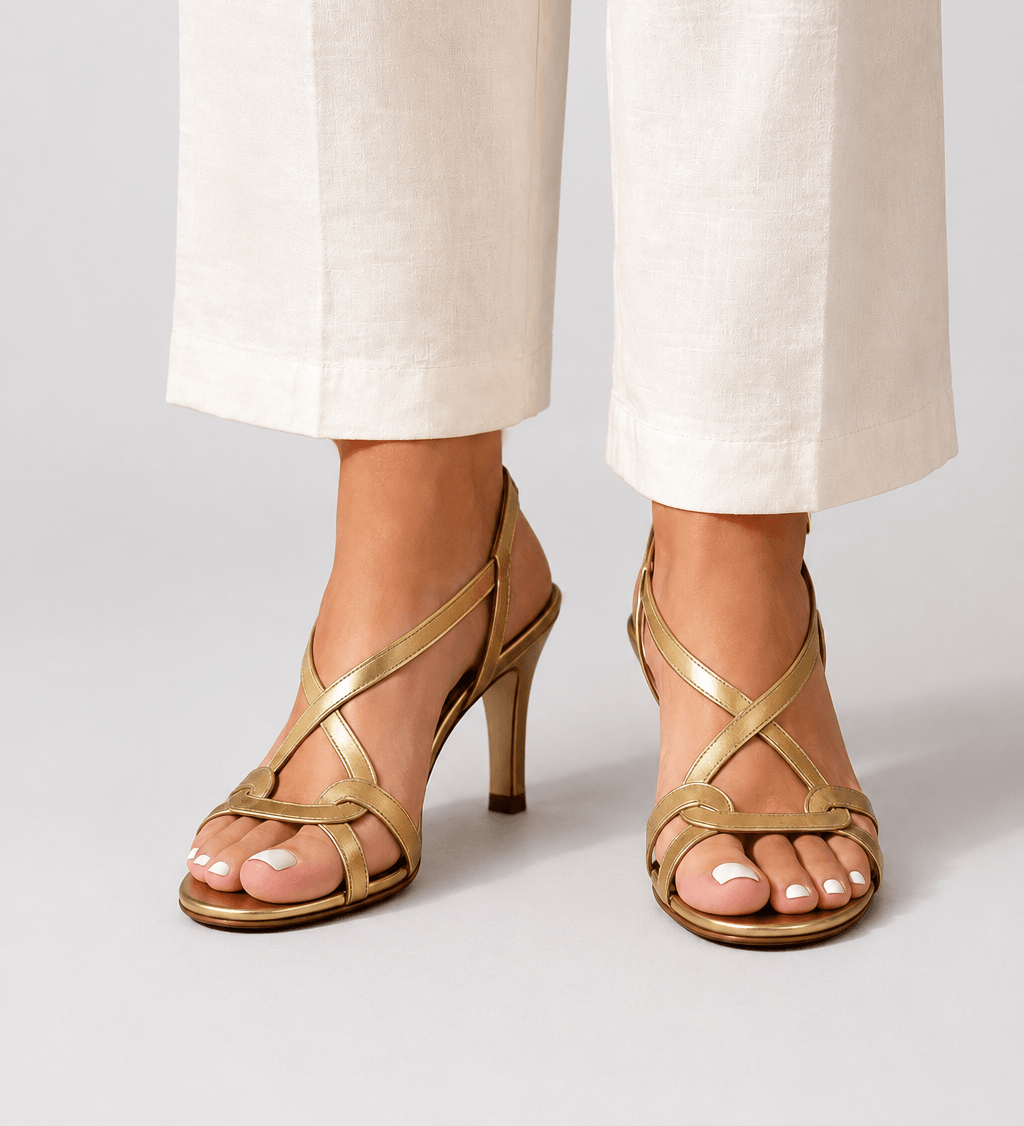 Gold open-toe heeled sandal with slim straps and small charm detail