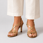 Gold open-toe heeled sandal with slim straps and small charm detail