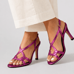Purple open-toe heeled sandal with crisscross straps and charm detail