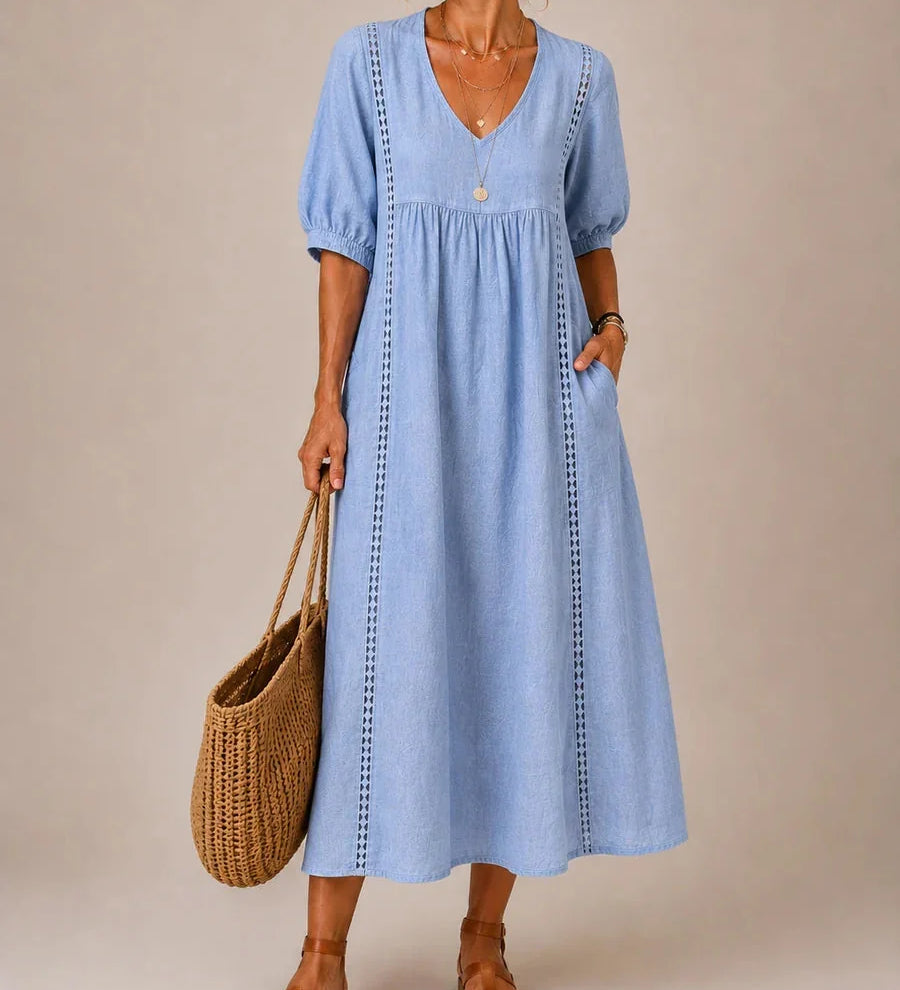 Light blue midi dress with V-neck, short puff sleeves, gathered bodice, and vertical stitched trim