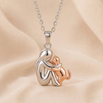 Hugging cat pendant necklace, silver-tone charm with rose-tone cat accents and chain