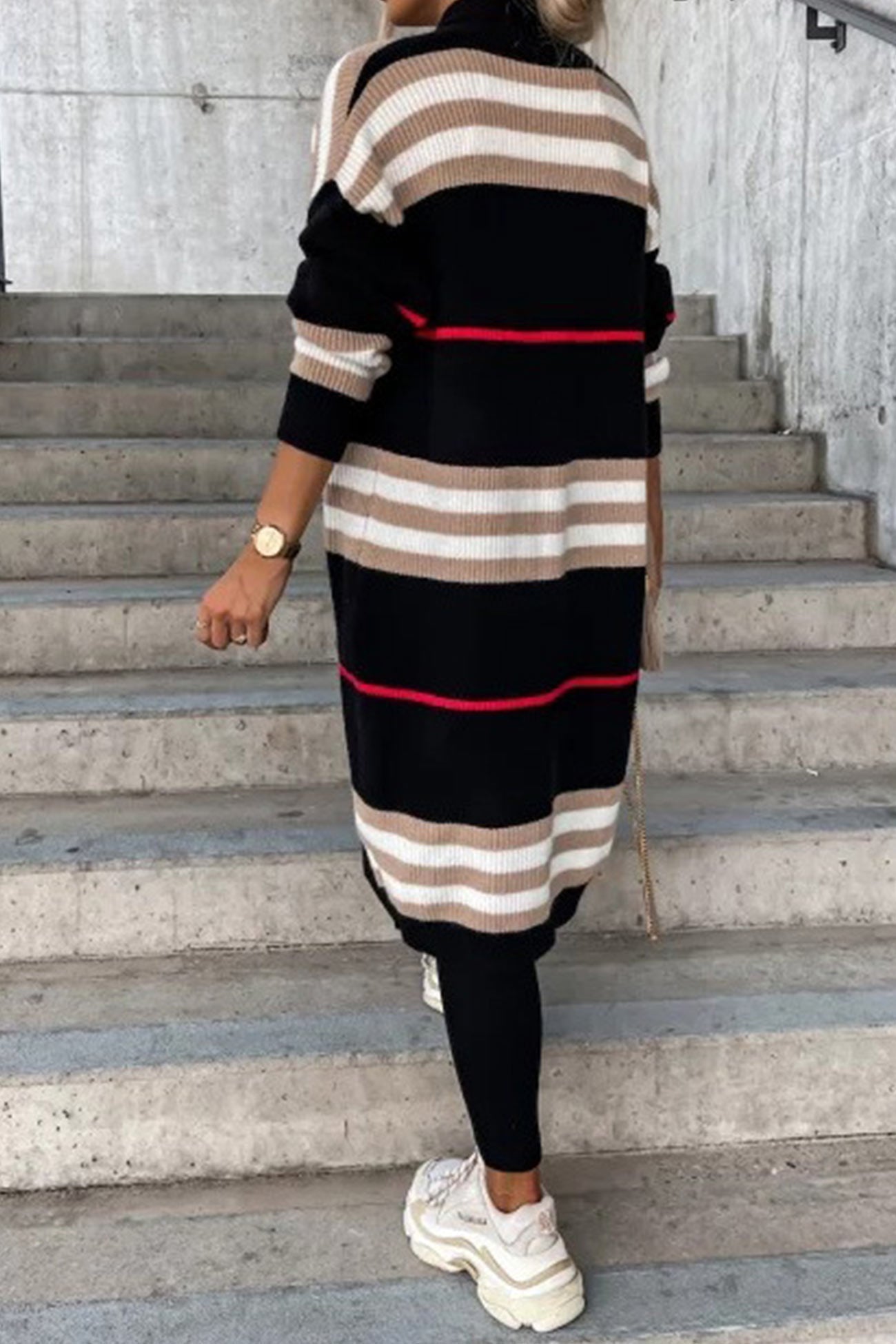 Long black cardigan with beige and white striped bands and thin red stripe.