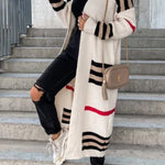 Long cream cardigan with black-and-white stripe bands and red accent stripe.