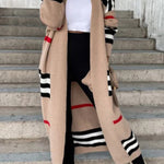 Long beige cardigan with black and white striped sleeves and red accent stripes.