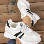 White and gray sport sneakers with black stripe accents, lace-up, cushioned sole