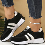 Black and white lace-up sport sneakers with three stripe detail and thick rubber sole