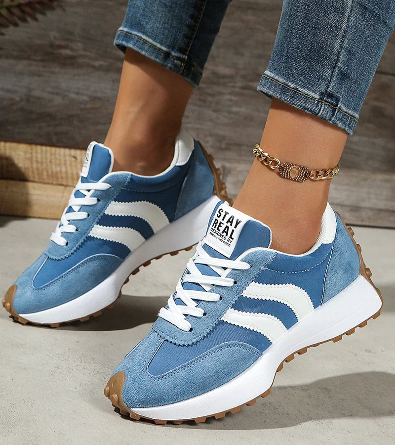 Blue suede-look lace-up sneakers with white adidas-style stripes and rugged sole