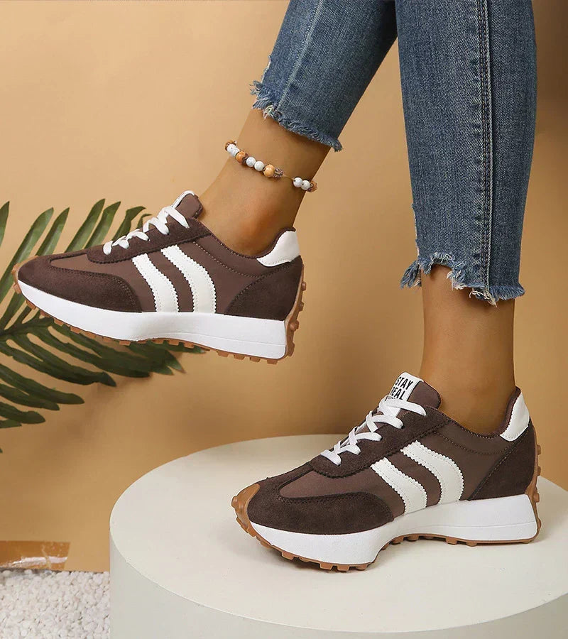 Brown and white lace-up sport sneakers with striped side panels, thick tread sole