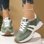 Green and white lace-up sport sneakers with white stripes and brown tread sole
