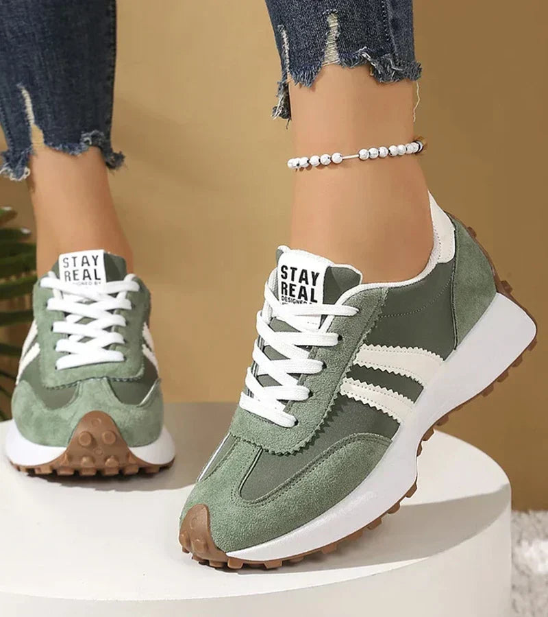Green and white lace-up sport sneakers with white stripes and brown tread sole