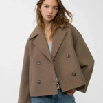 Taupe double-breasted coat with notch lapels, button detail, flap pockets.