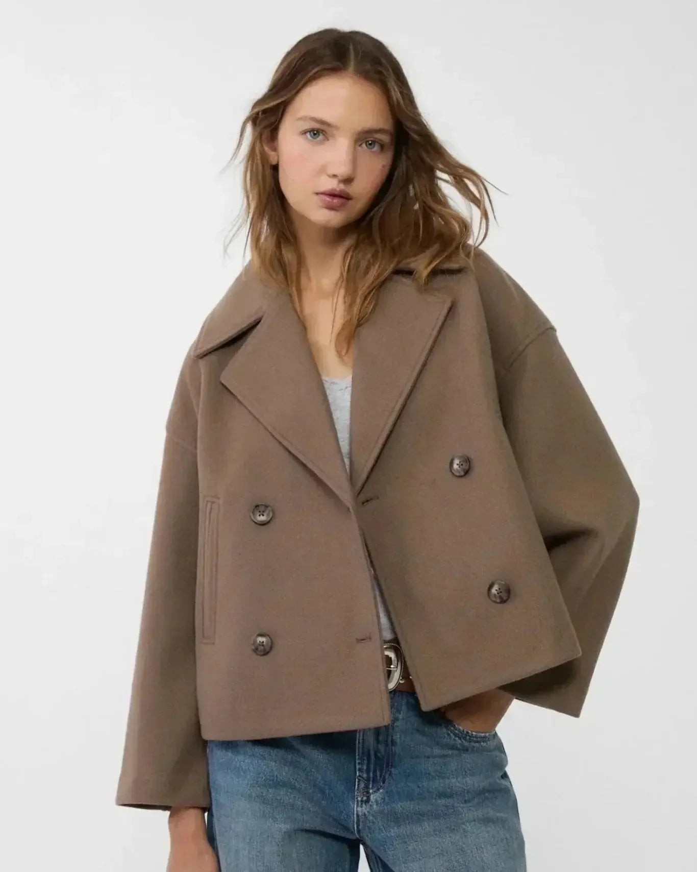 Taupe double-breasted coat with notch lapels, button detail, flap pockets.