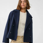 Navy double-breasted coat with wide lapels and buttoned flap pockets.