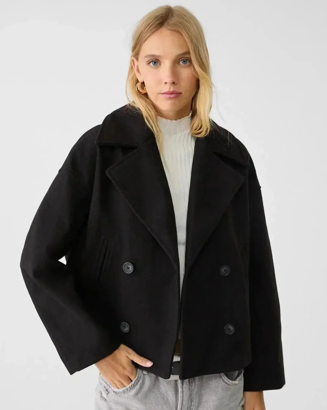Black double-breasted coat with wide lapels and silver button detail.