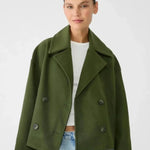 Green double-breasted coat with notch lapels and buttoned flap pockets.