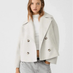 Off-white double-breasted coat with wide lapels and buttoned flap pockets.
