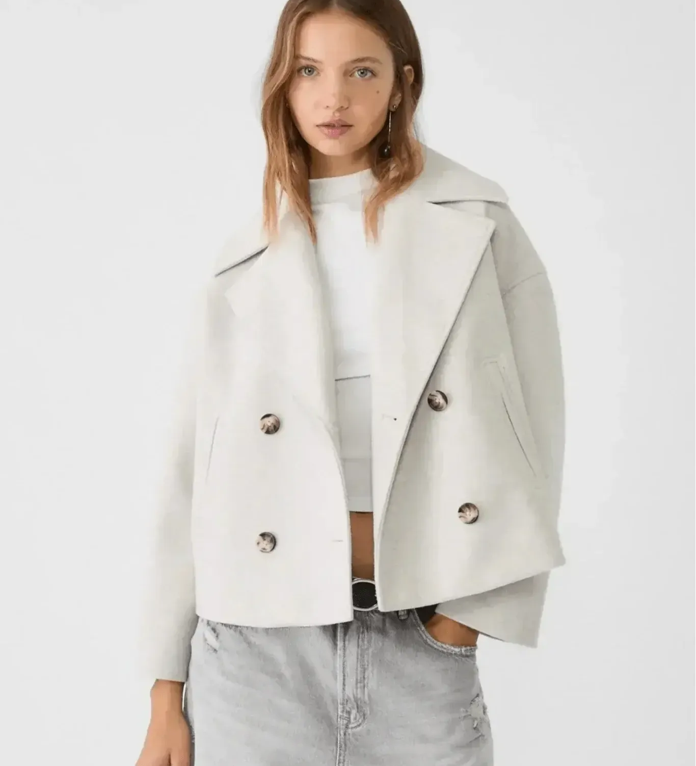 Off-white double-breasted coat with wide lapels and buttoned flap pockets.
