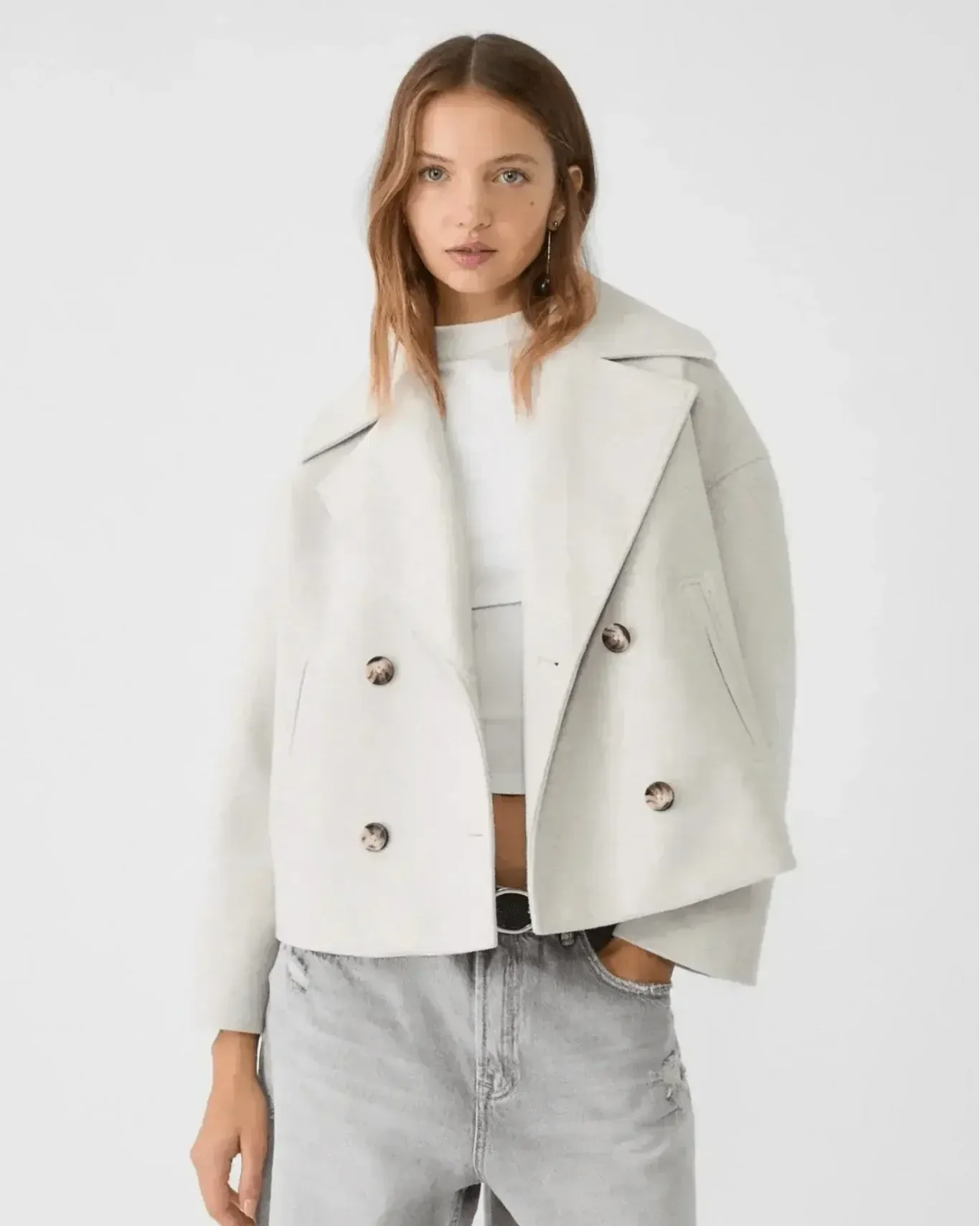 Off-white double-breasted coat with wide lapels and buttoned flap pockets.