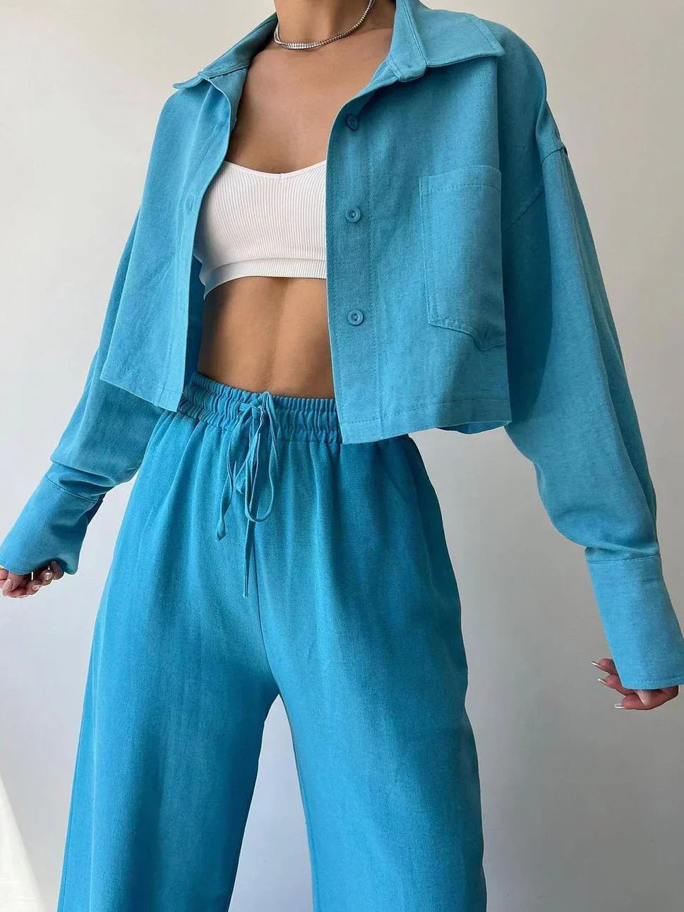 Teal-blue two-piece set with collared button-up top and wide drawstring waist trousers