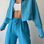 Teal-blue two-piece set with collared button-up top and wide drawstring waist trousers
