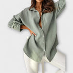 Sage green women’s button-front blouse with long sleeves and collar.