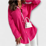 Fuchsia women’s button-front blouse with long sleeves and V-neck opening.