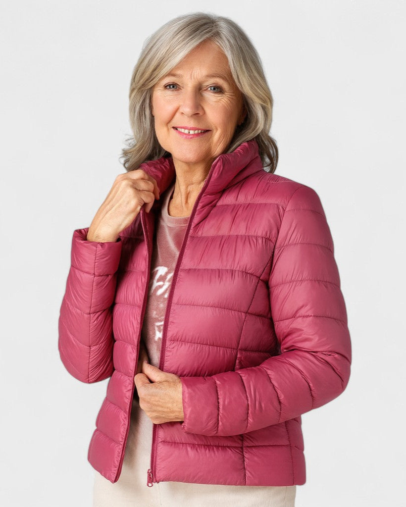Magenta puffer jacket with full zipper and stand collar, worn with long sleeves.