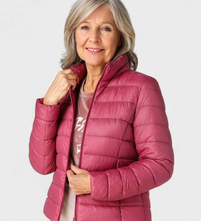 Magenta puffer jacket with full zipper and stand collar, worn with long sleeves.