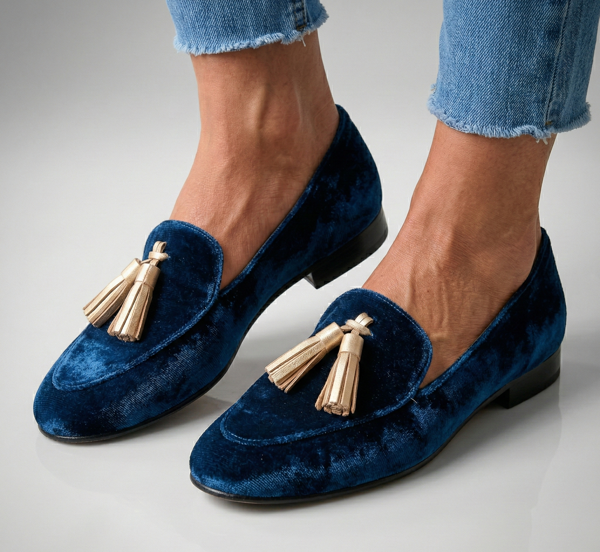 Classic dark blue velvet loafers with gold tassel detail, side view