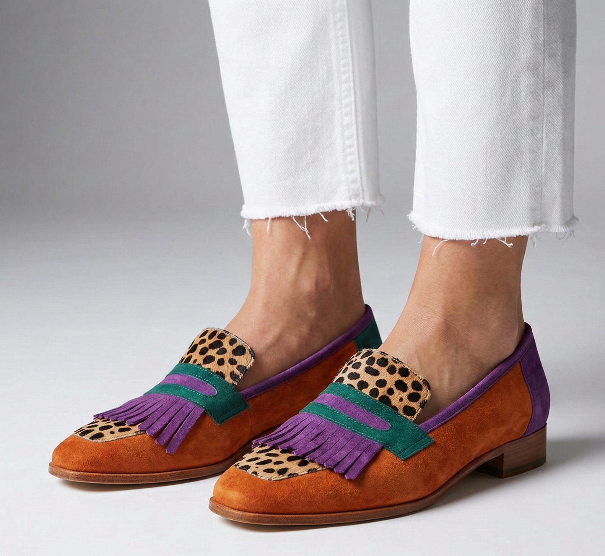 Brown suede moccasin loafers with leopard-print panels, purple and teal straps, fringe
