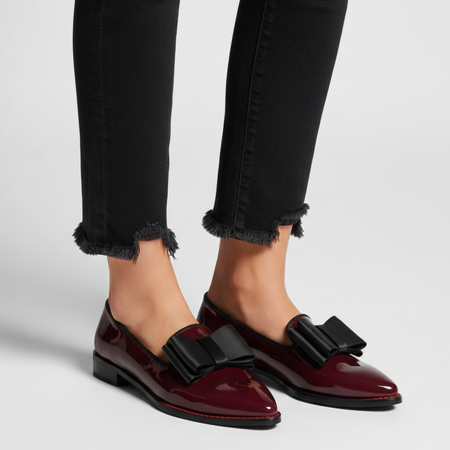 Chrysa glossy burgundy loafers with black strap buckle, worn with frayed jeans cuffs