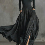 Black maxi dress with long sleeves, high waist ruching, and flowy pleated skirt