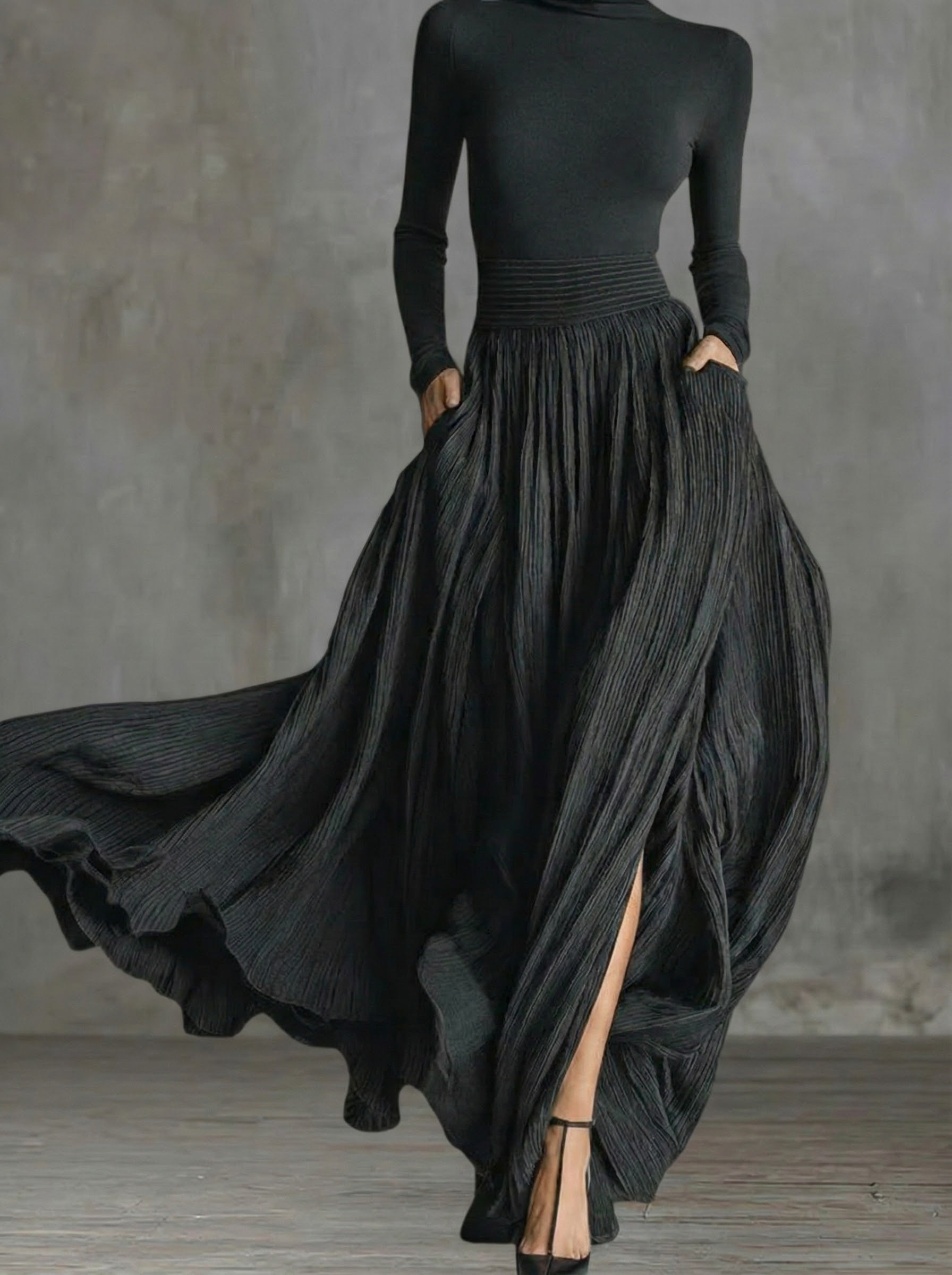 Black maxi dress with long sleeves, high waist ruching, and flowy pleated skirt