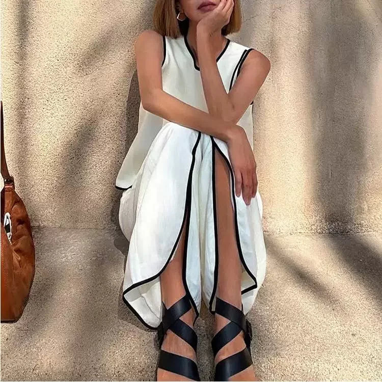 Women's white sleeveless draped top and wide-leg pants with black trim and belt