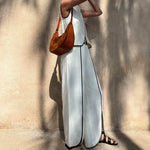 Women's white sleeveless set with black piping, belted waist, and flowing pant overlay