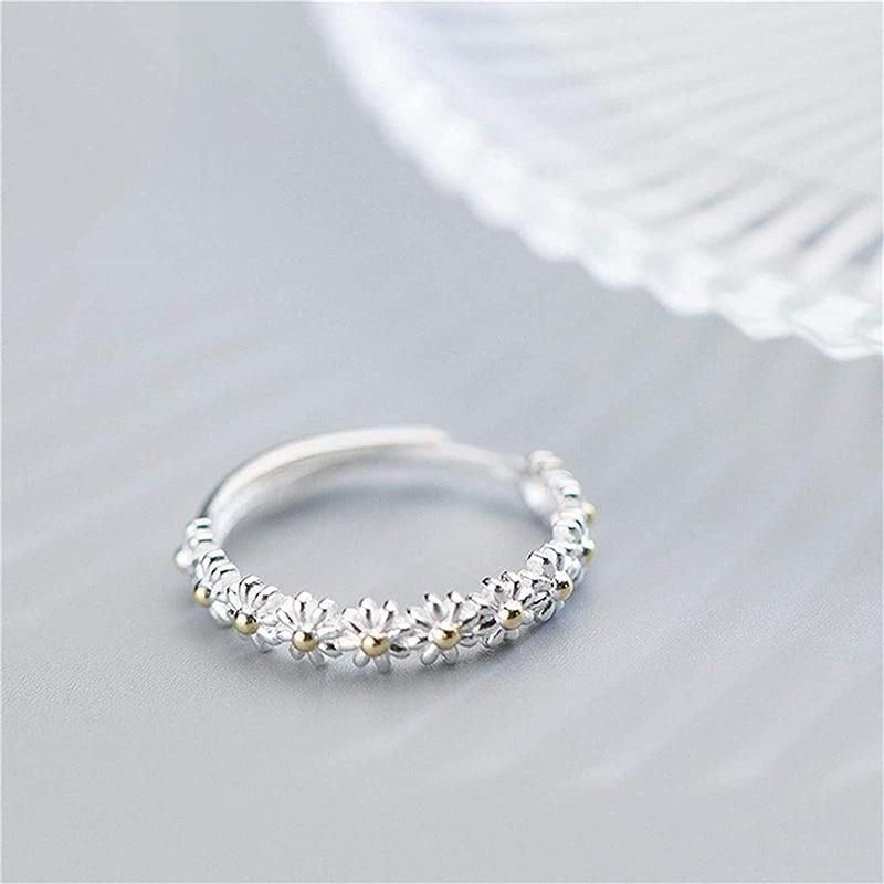 Silver daisy ring with gold-centered flowers, loop band