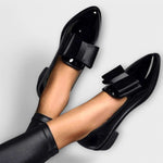 Chrysa glossy black loafers with black strap buckle, close-up side view
