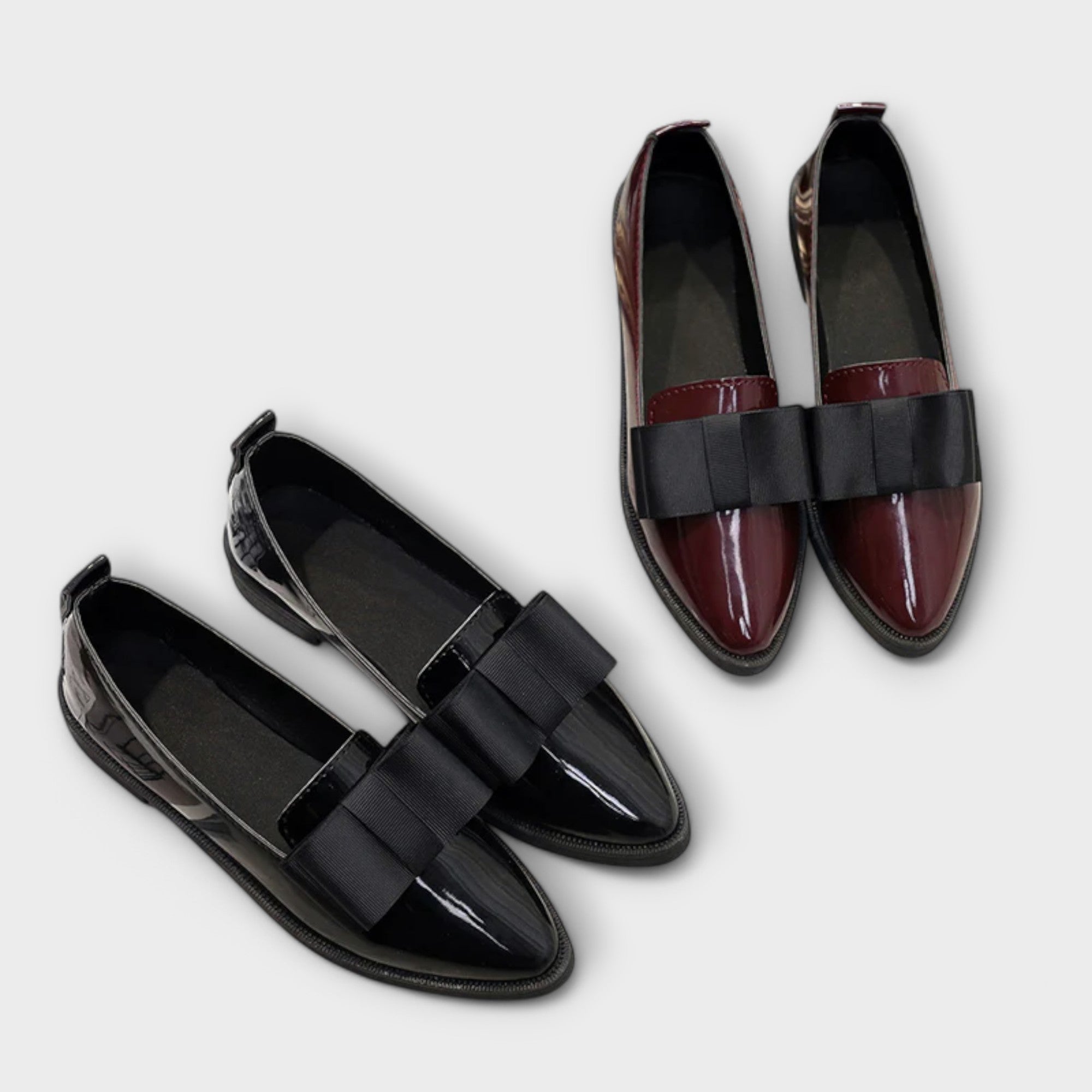 Chrysa glossy burgundy loafers with black strap buckle, pair on flat surface