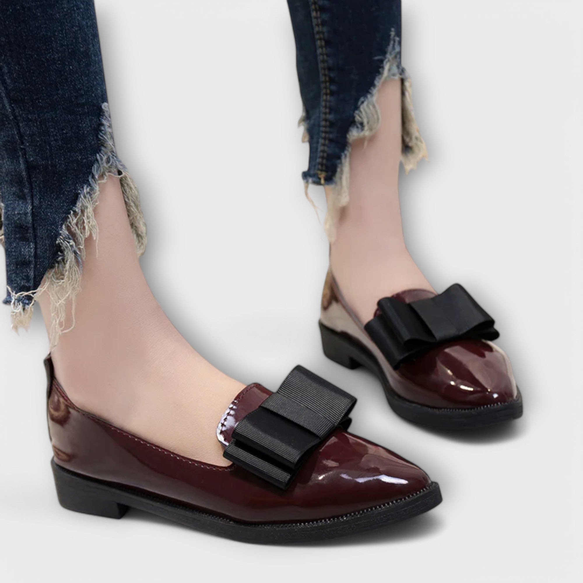 Chrysa glossy burgundy loafers with black strap buckle, worn with distressed jeans