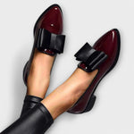 Chrysa glossy burgundy loafer pair with black strap buckle, close-up side view