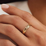 Gold-tone multi-band ring with curved ridged bands, worn on a finger